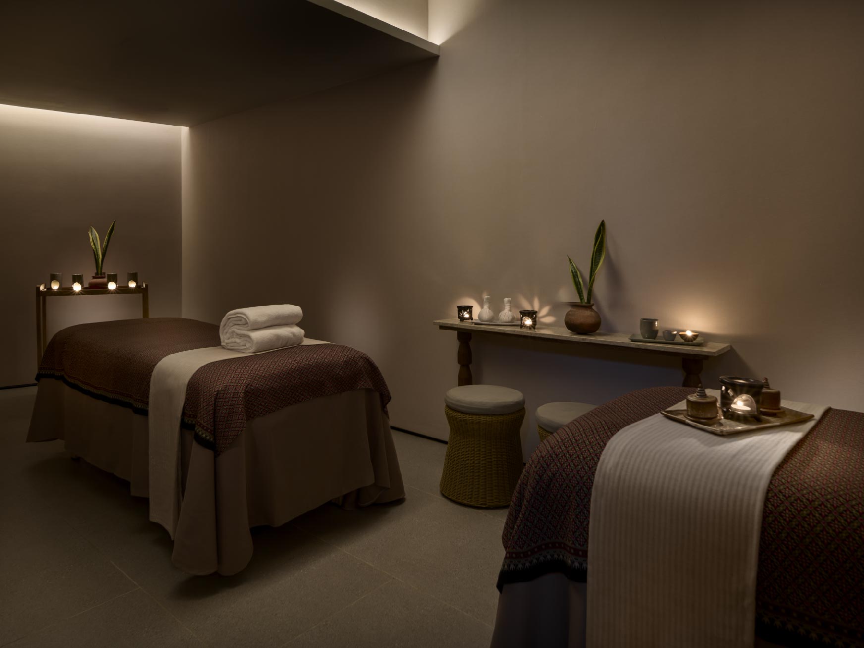 Two massage beds with rolled towels in a treatment room.