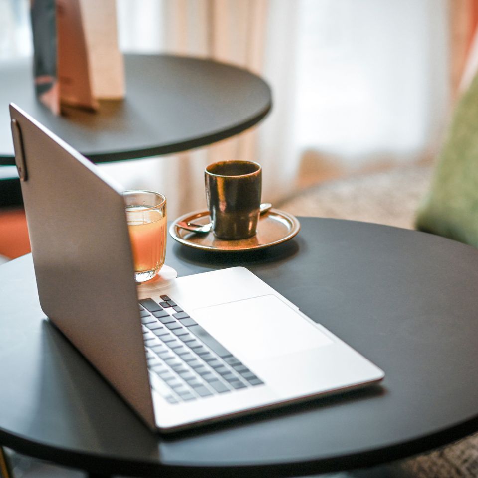 Laptop and espresso on a small table.