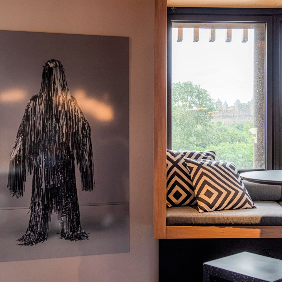 Framed monochrome artwork beside a window seat.