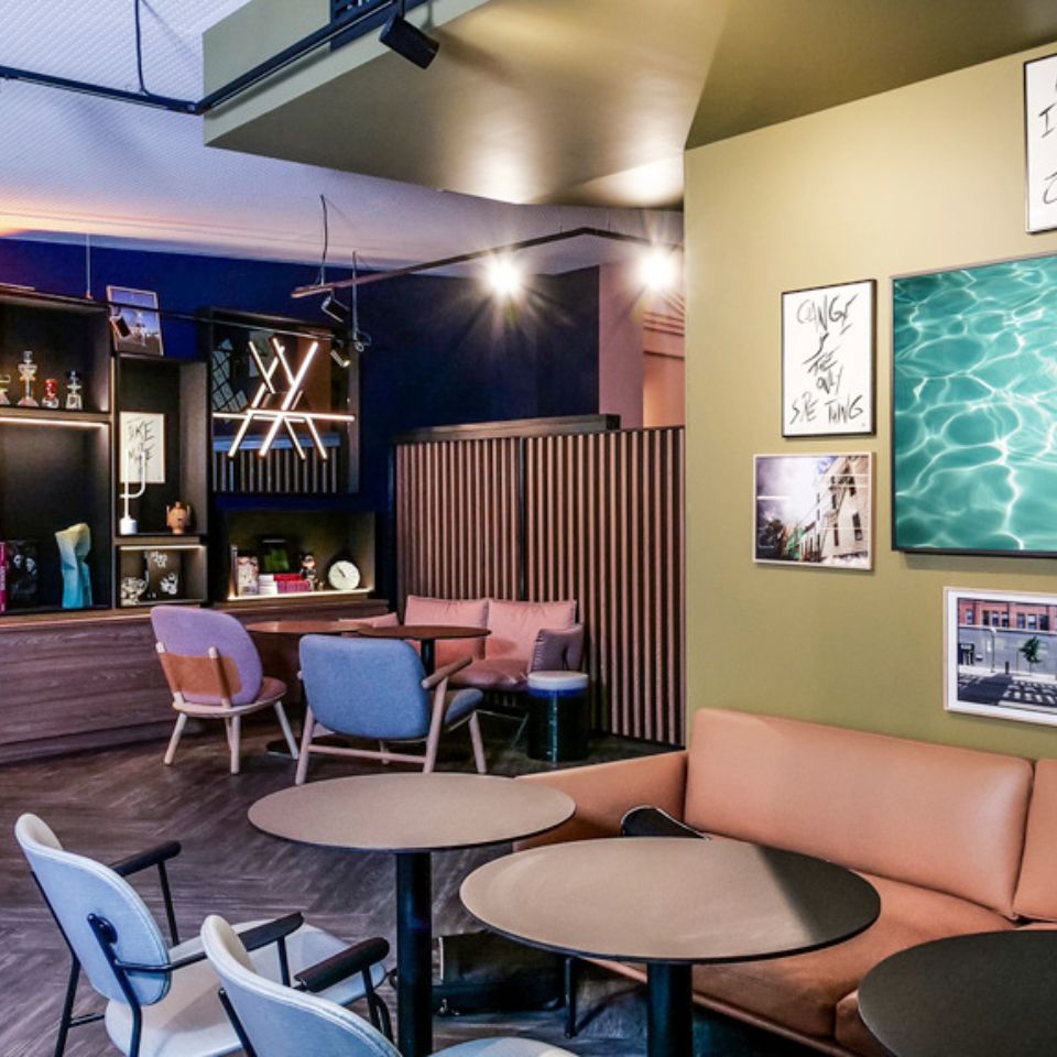 Common area at TRIBE Batignolles with several different chairs, couches and tables
