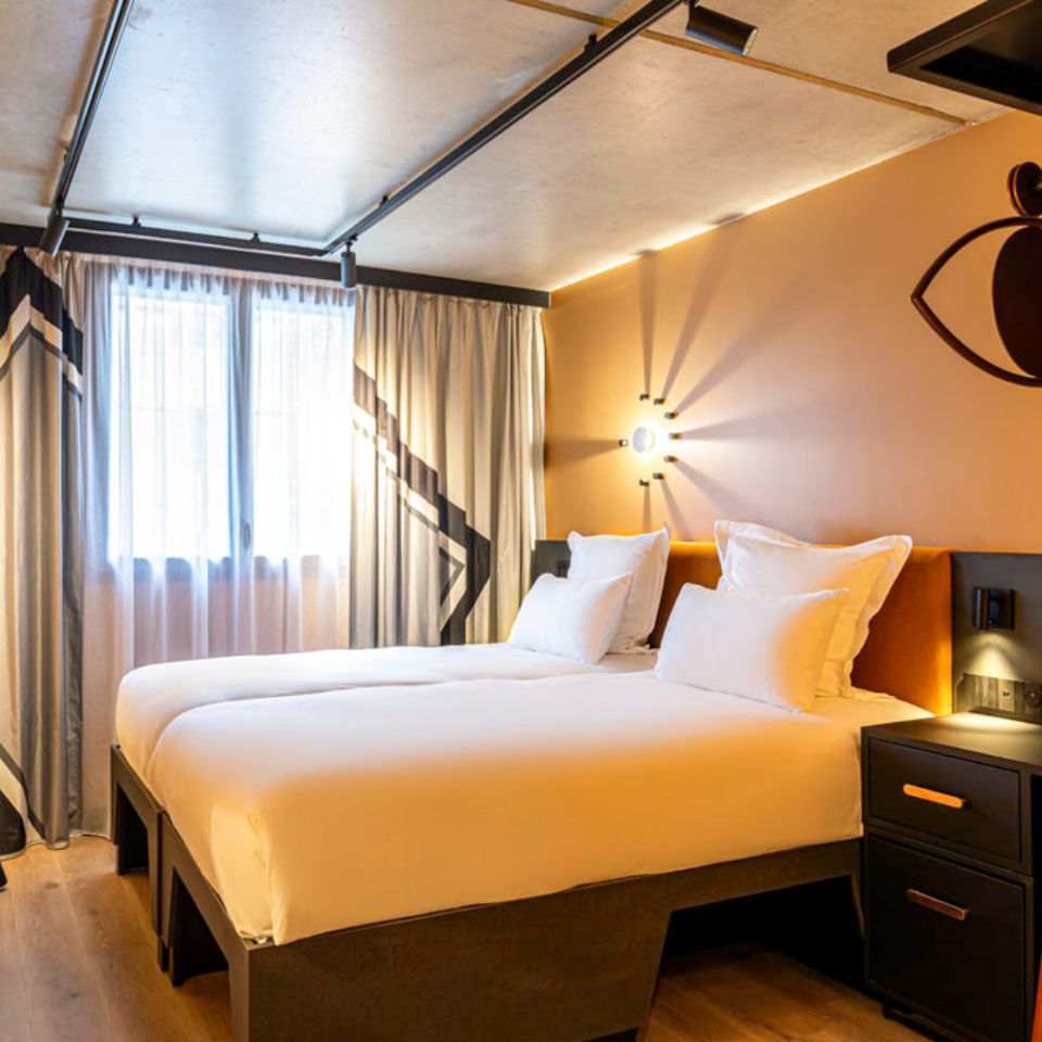 Guest Room with a twin bed, small desk and window with curtains