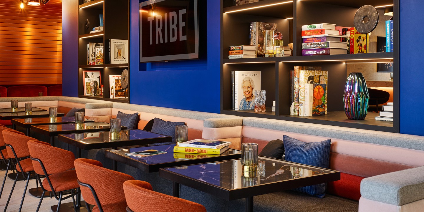 Living Space with several orange and blue chairs, couches and decorations on the walls, like pictures and shelves