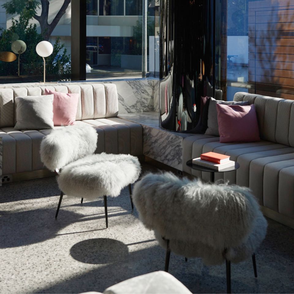 Two couches and two cozy chairs around a small black coffeetable with books on top of it.