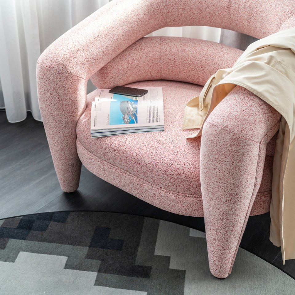 Pink armchair with a magazine and a dress on it