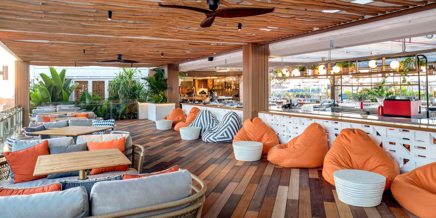 Outdoor restaurant space with several tables and lounge chairs