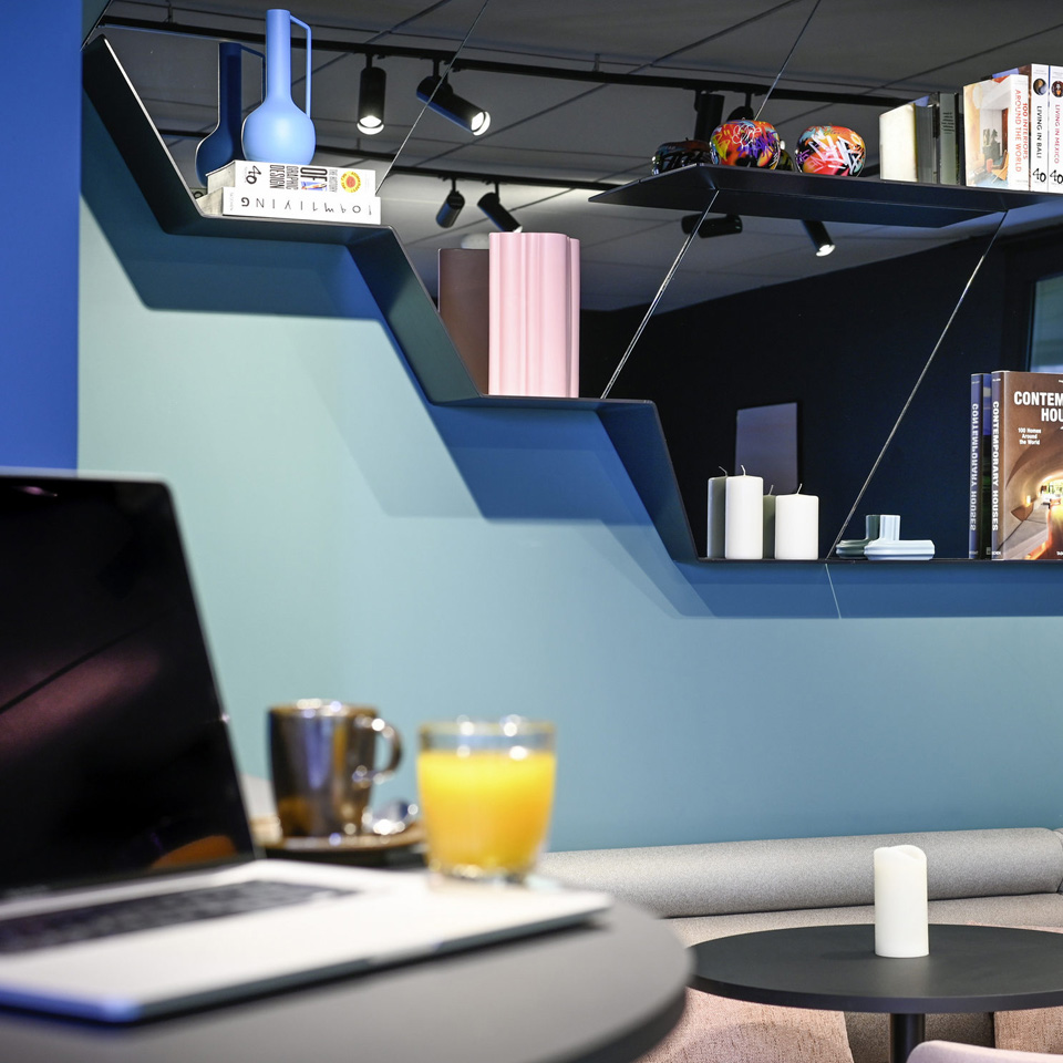 Lounge seating with drinks on a small table beneath decorated shelves.