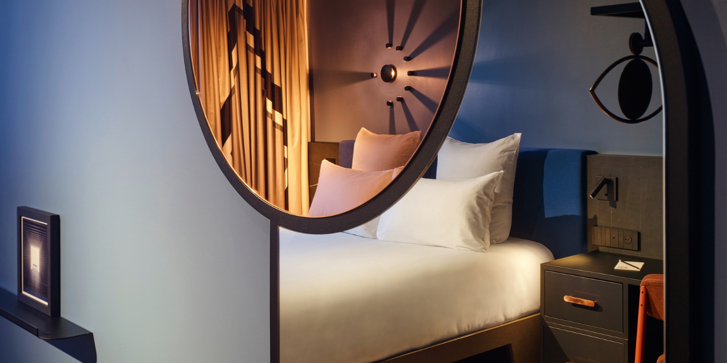 Bedroom reflected in a large round mirror.