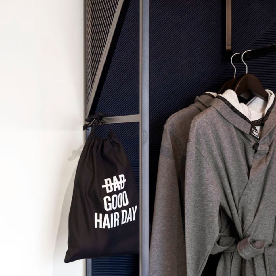 Bathrobe and tote bag hanging in an open wardrobe.