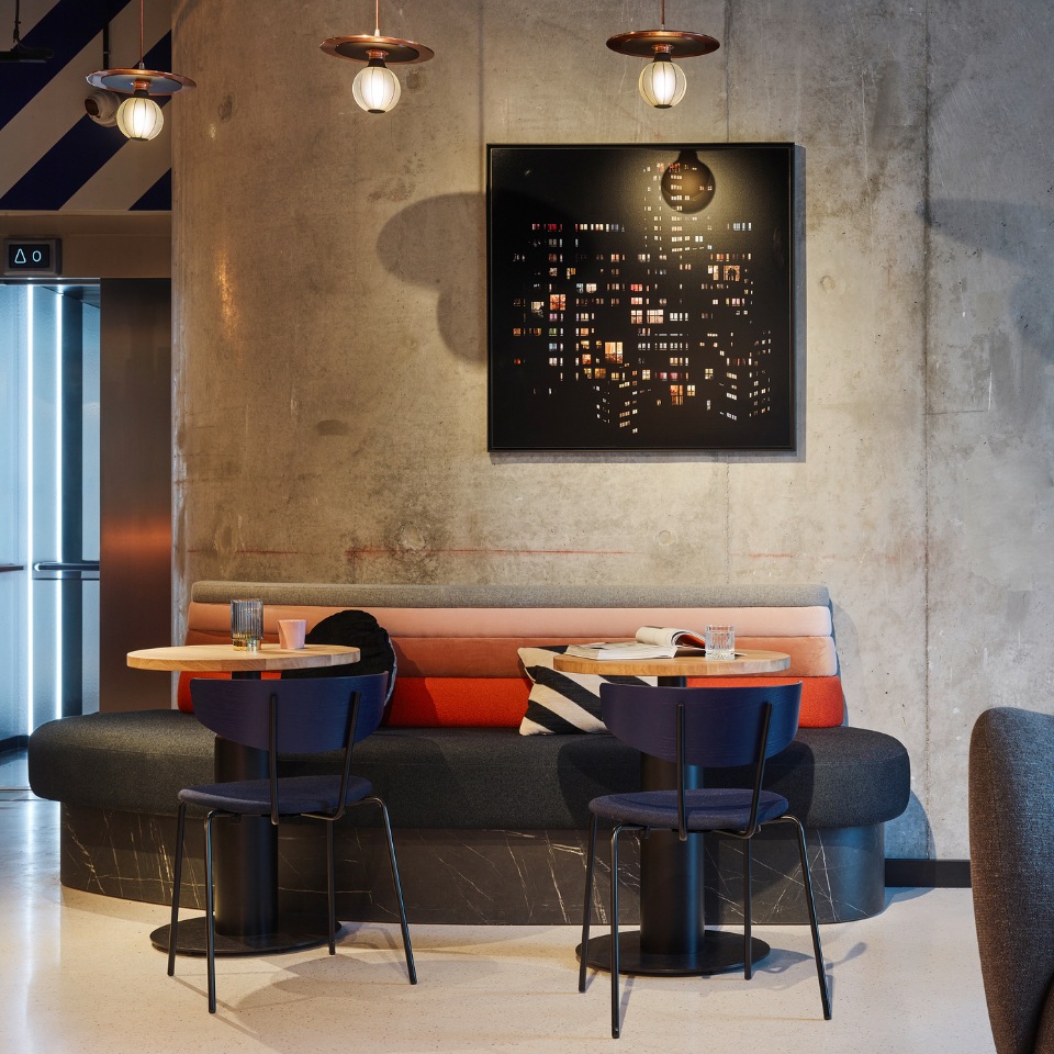 Lounge seating and small tables beneath a framed artwork.