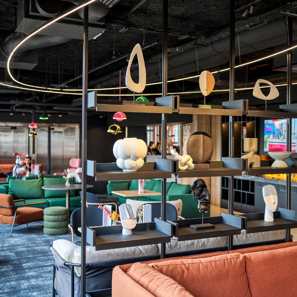 Open shelves with books and decorative objects divide a colourful lounge.