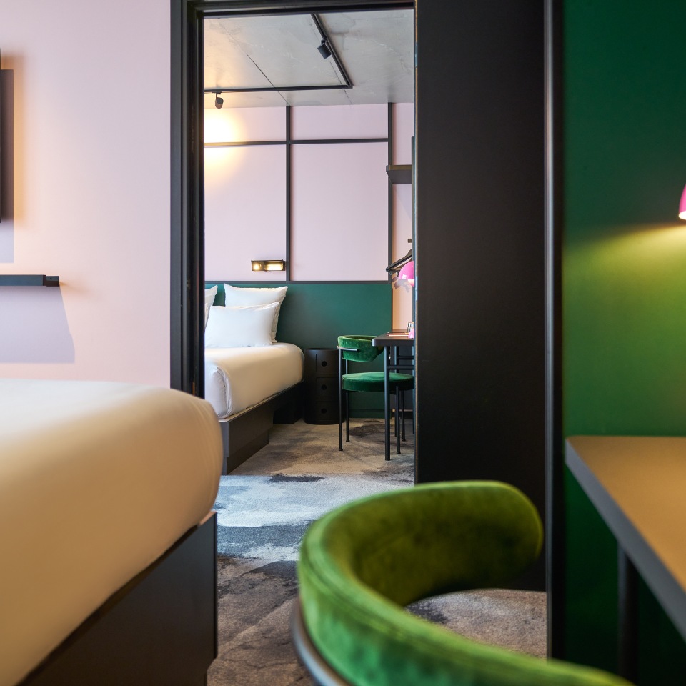 Bedroom with green and pink walls and a mirrored wardrobe.