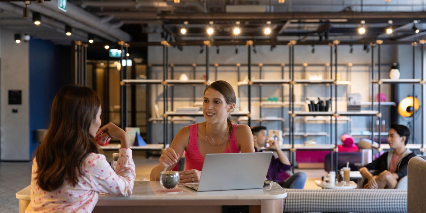 Two people engaging in conversation in a lively living space.