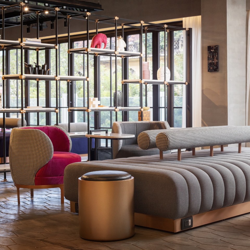 Lounge with open shelves, sofas and round stools.