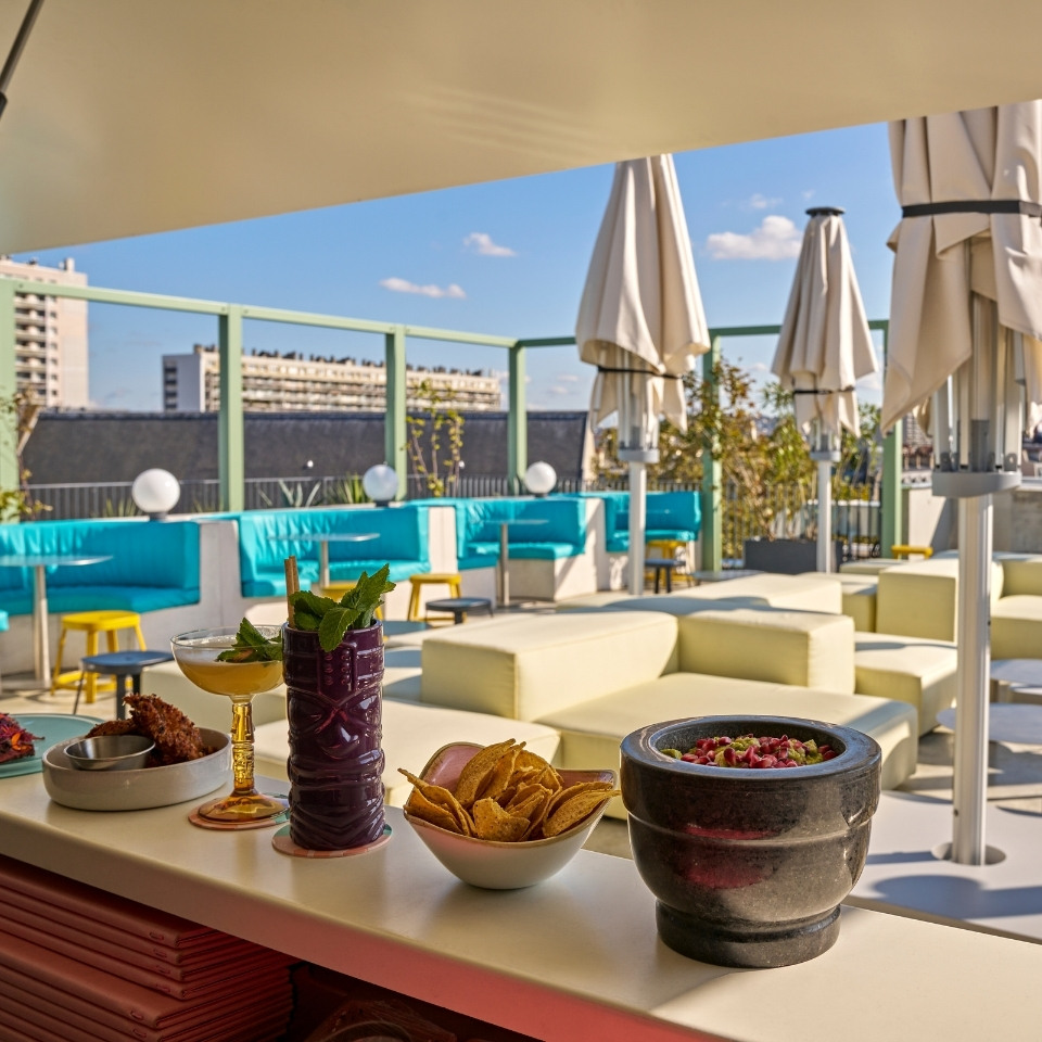 Cocktails and small plates on a rooftop terrace overlooking the city.