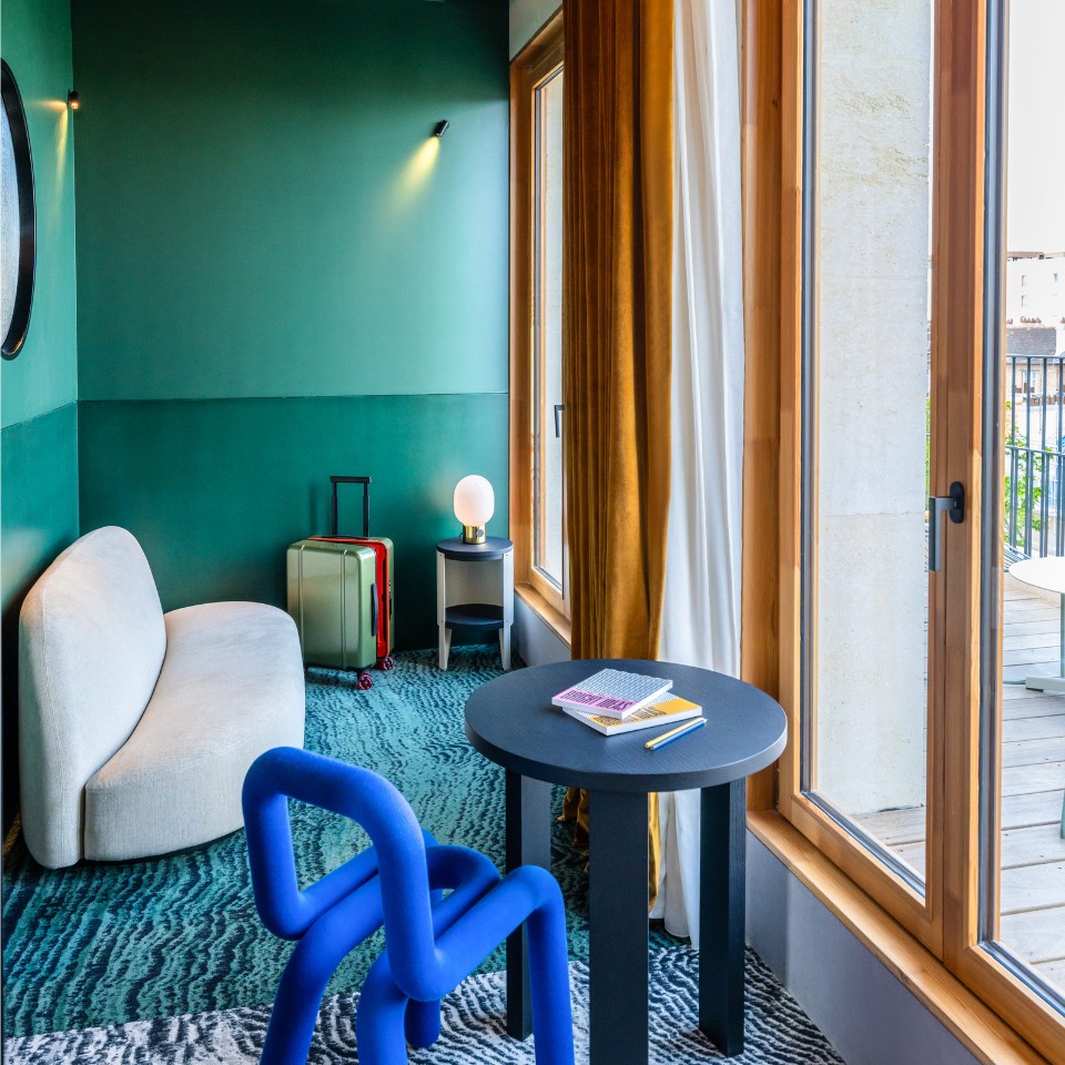 Seating area with a blue chair and sofa beside the terrace door.