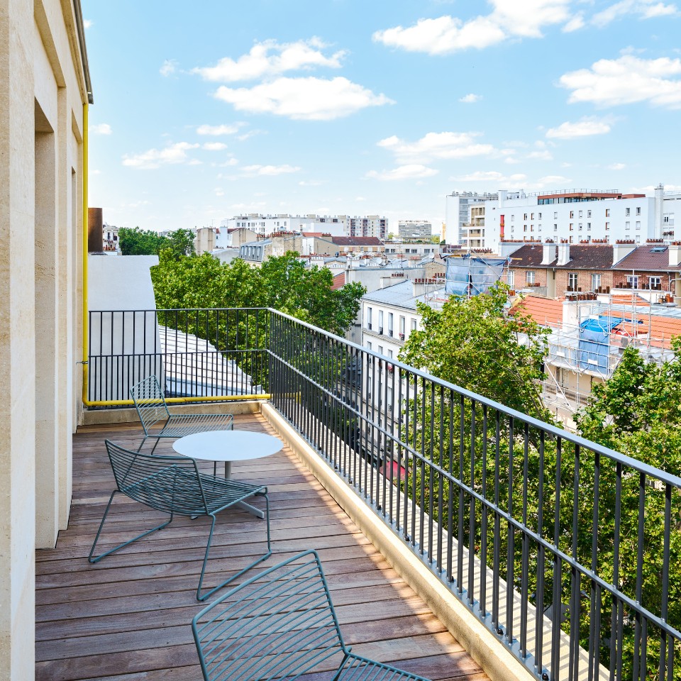 Balcon aménagé avec vue sur les toits de la ville.