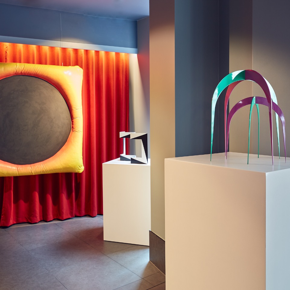 Colourful sculptures displayed in a gallery-like space.
