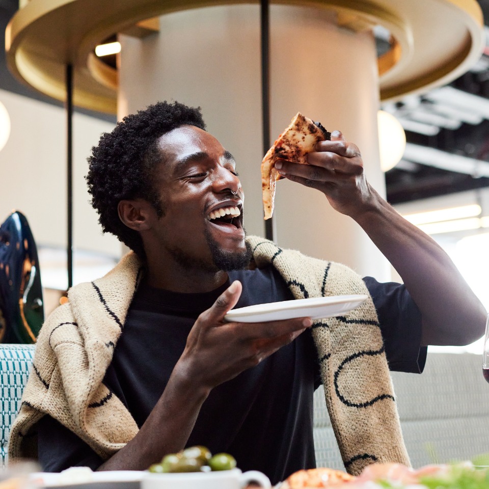 A person enjoying a slice of pizza.
