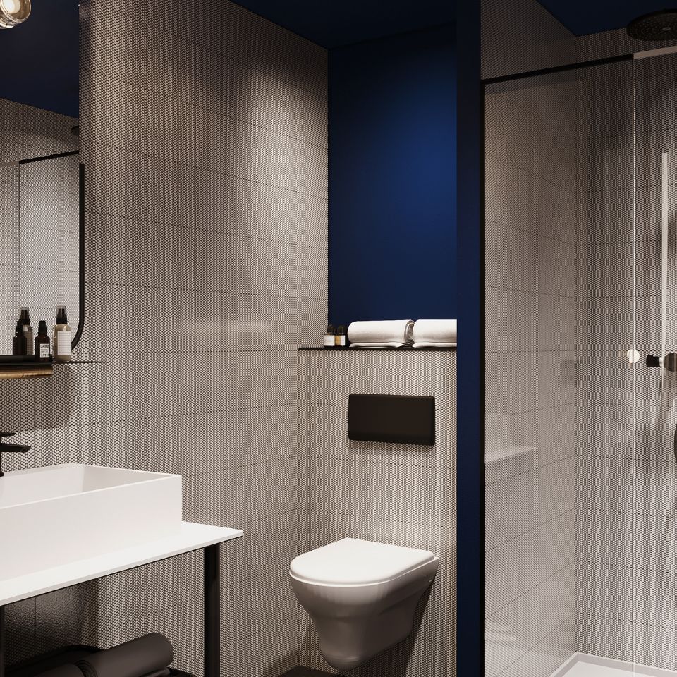 Bathroom with shower, toilet and dark blue accent wall.