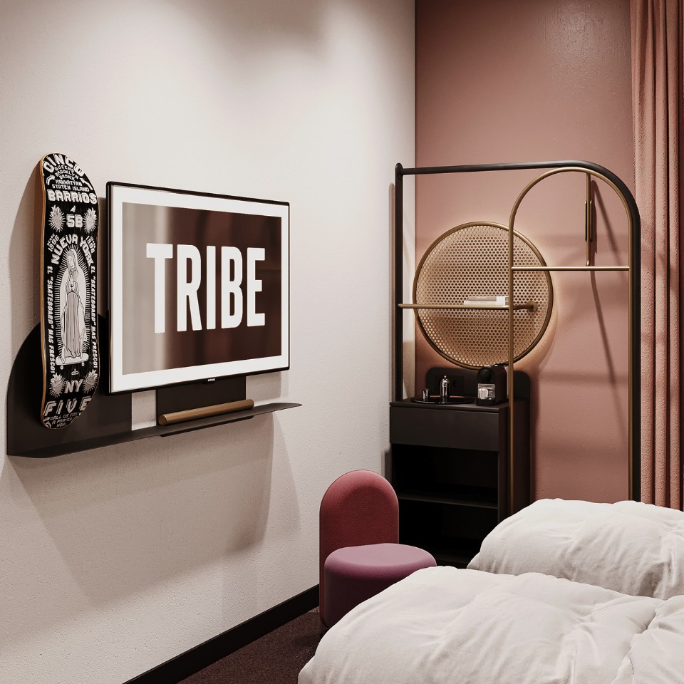 Twin beds, pink chair and screen showing the TRIBE logo.