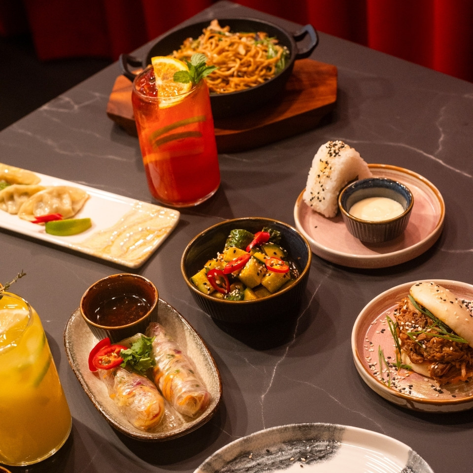 Une table garnie de plats et de boissons variés, présentant un buffet coloré pour une réunion conviviale.