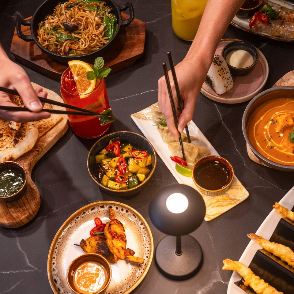 Une table garnie d’un assortiment de plats et de boissons, prête pour un repas ou une fête.