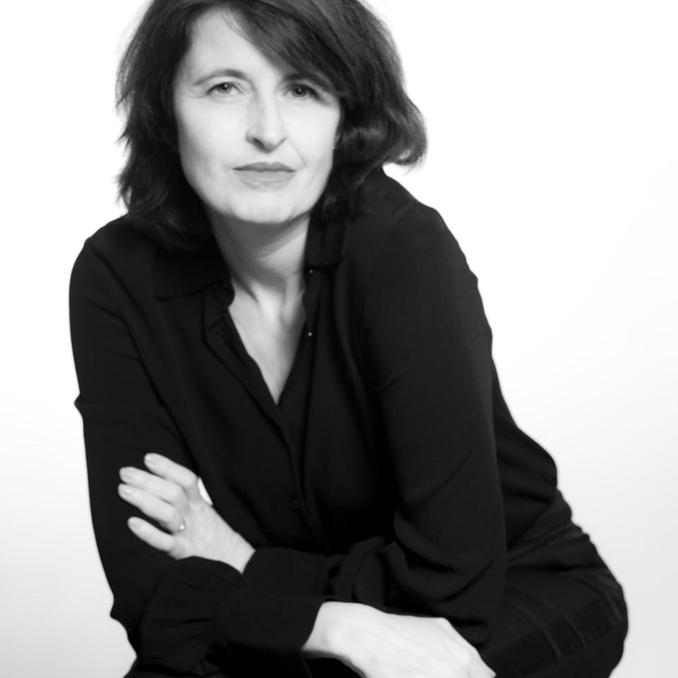 Black-and-white portrait of a woman with folded arms.