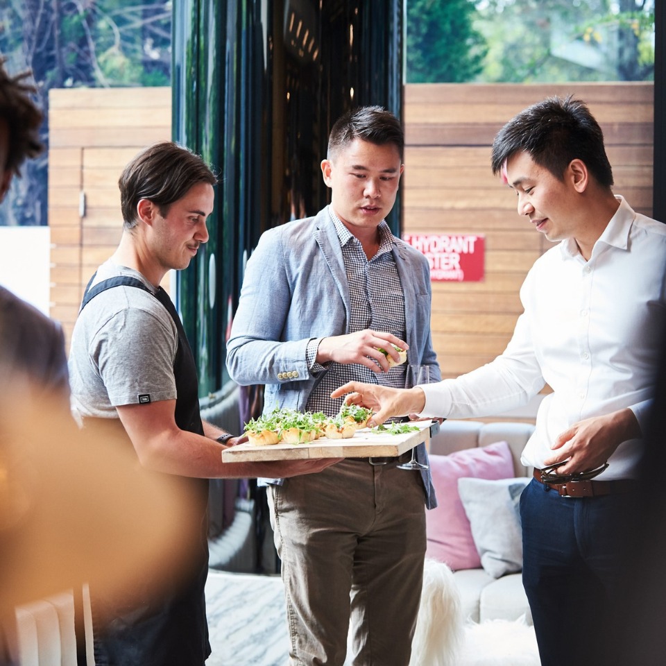 A member of staff offers food to guests during a break.