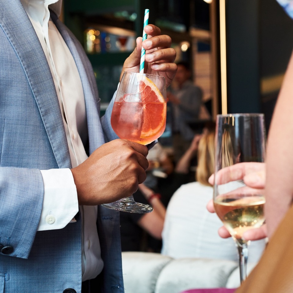 Guests holding drinks at a reception.