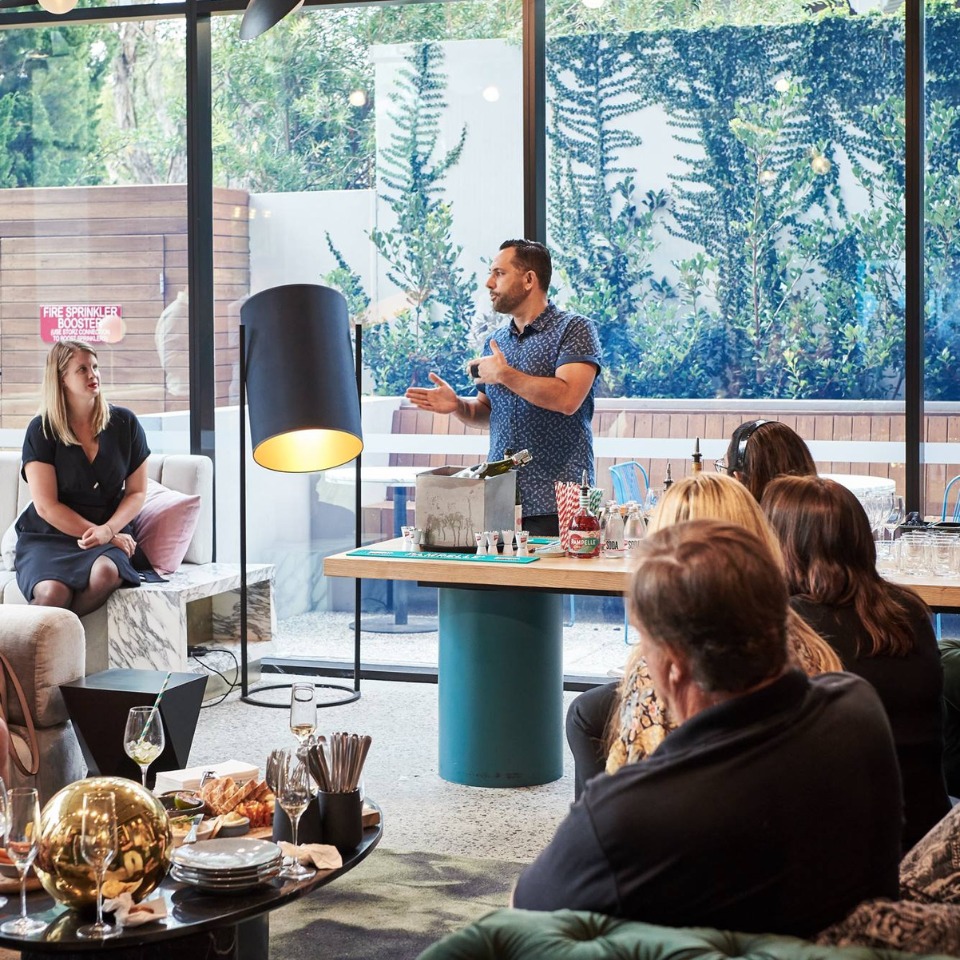 A speaker addresses a group seated in a lounge.