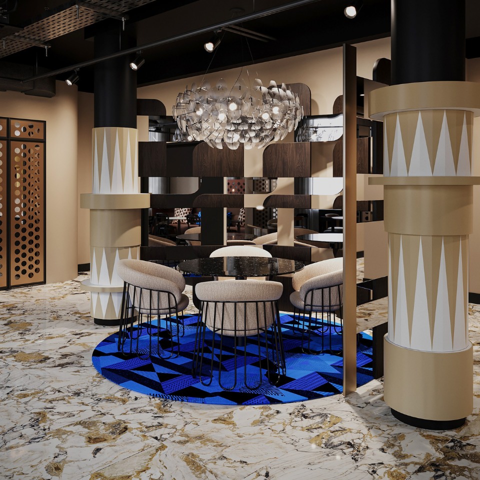 Modern dining area with a round black table, cream chairs, and a striking blue geometric rug. A sculptural, glass chandelier hangs above, adding elegance.