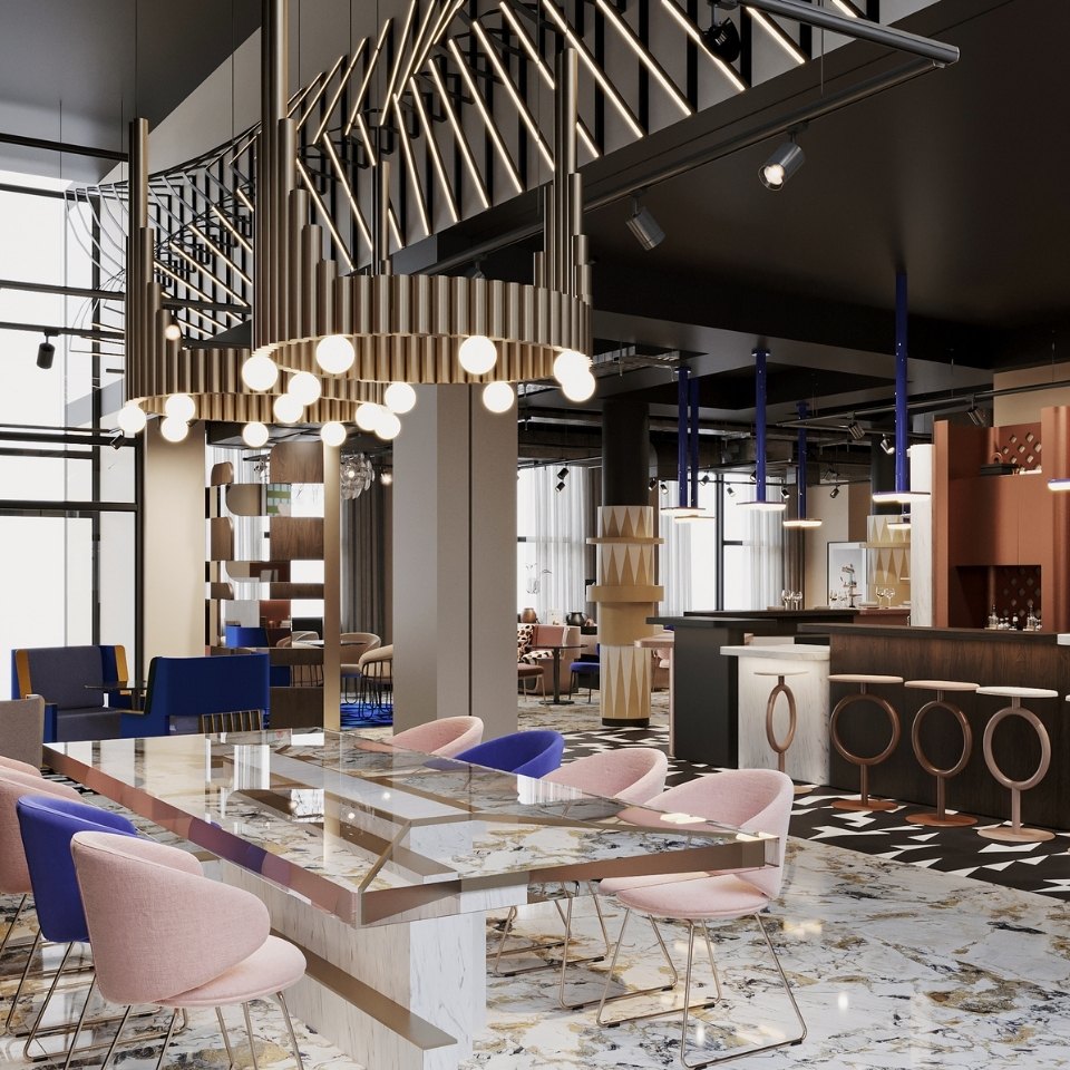 Modern lounge with polished marble floors, a sleek bar, and a large table surrounded by pink and blue chairs. Stylish lighting adds an elegant touch.