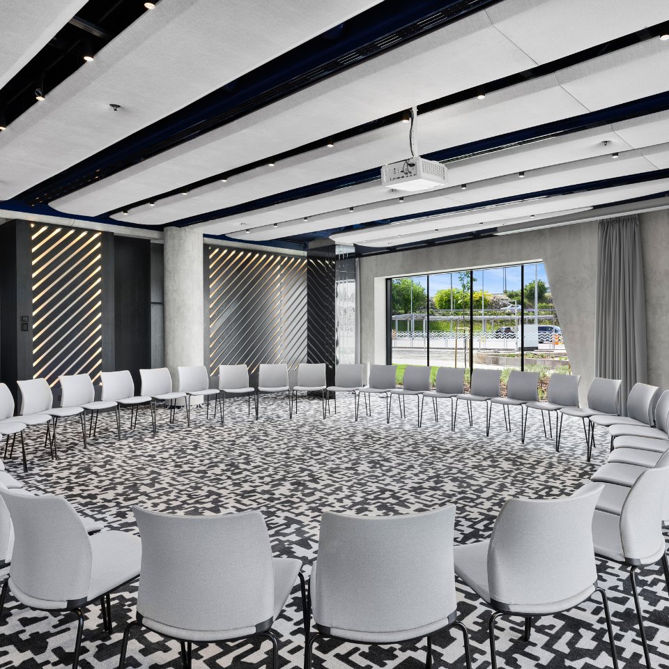 White chairs arranged around the walls of a large conference room.
