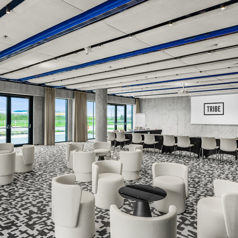 High tables with refreshments beside conference seating.