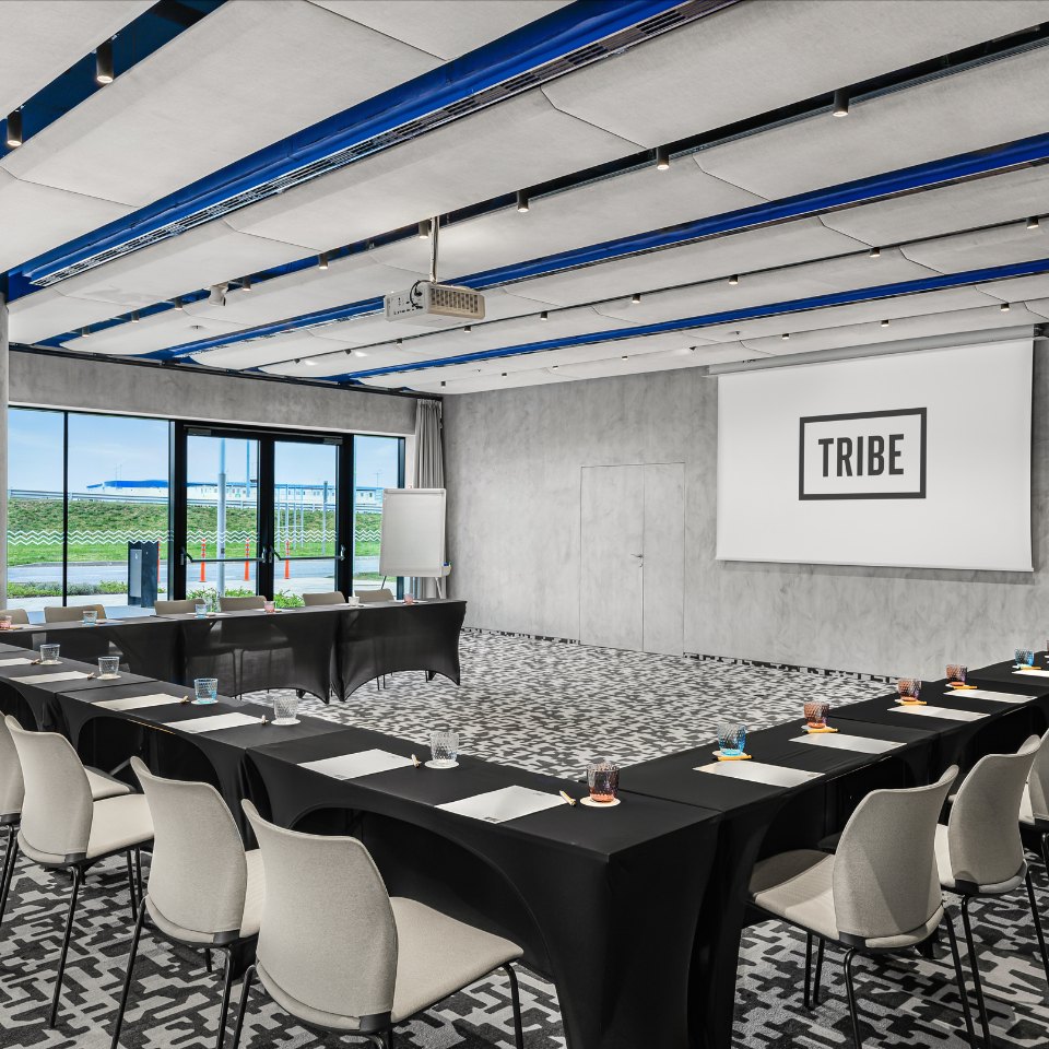 U-shaped conference tables with notebooks and pencils.
