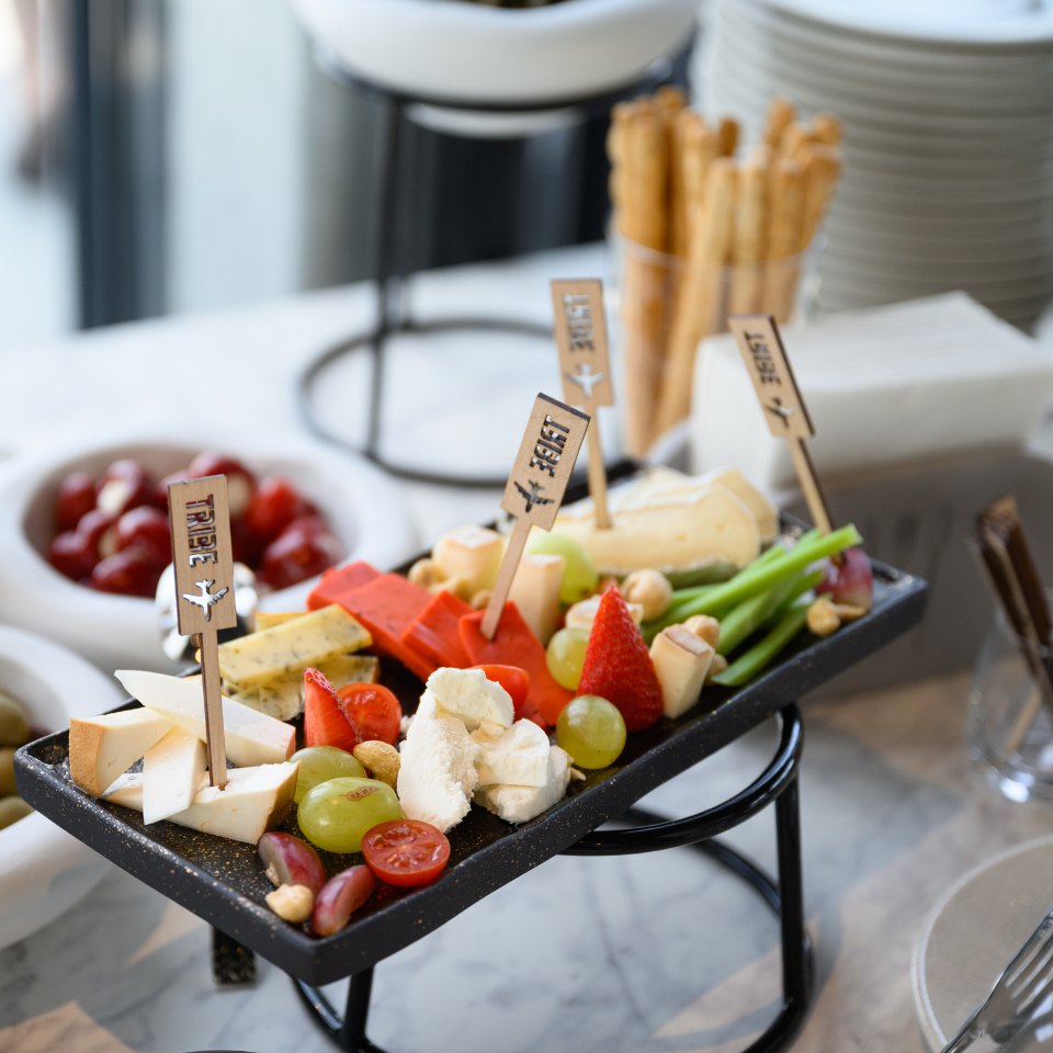 Vegetables, cheese and breadsticks on a refreshment tray.
