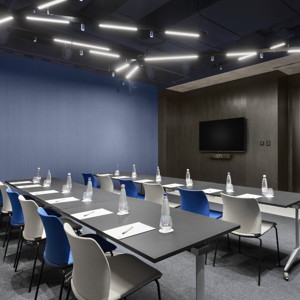 U-shaped meeting tables with bottled water and glasses.