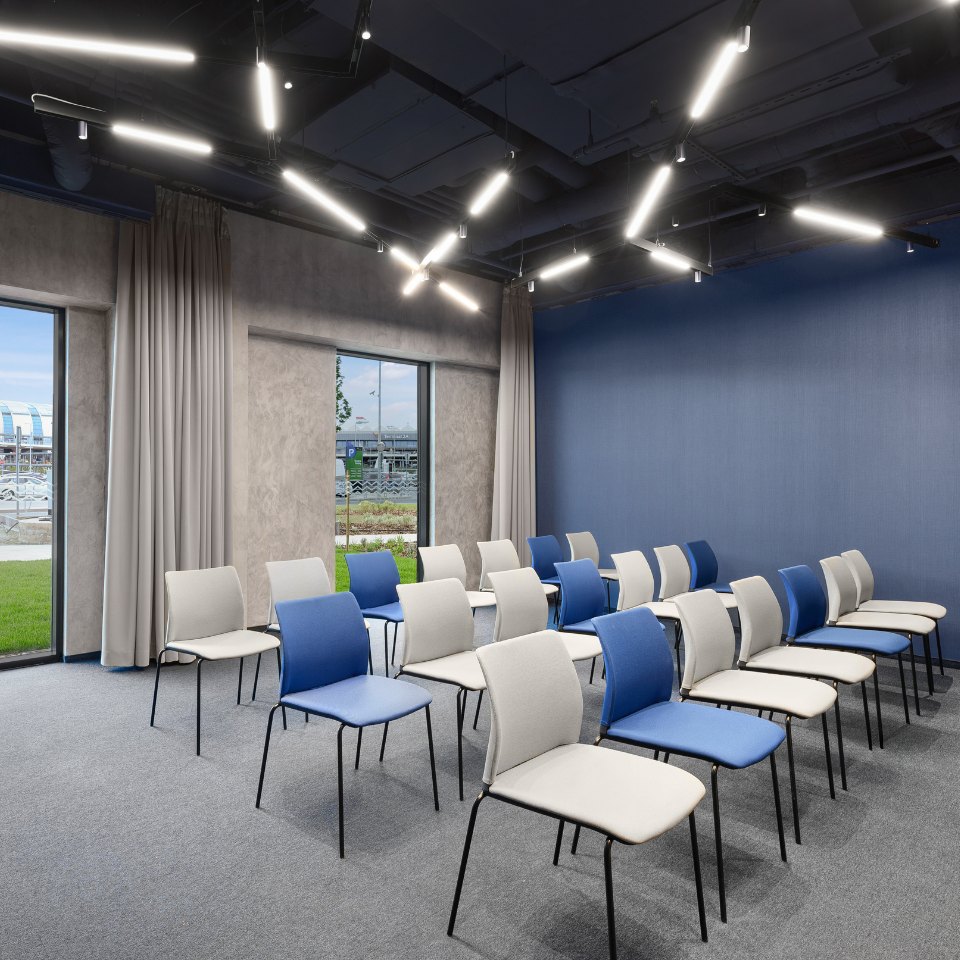 Rows of blue and white chairs facing a presentation area.