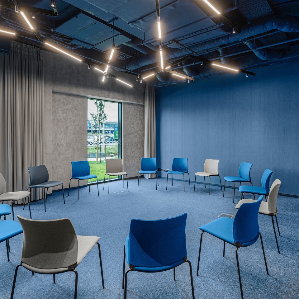 Meeting chairs arranged in a circle beside large windows.