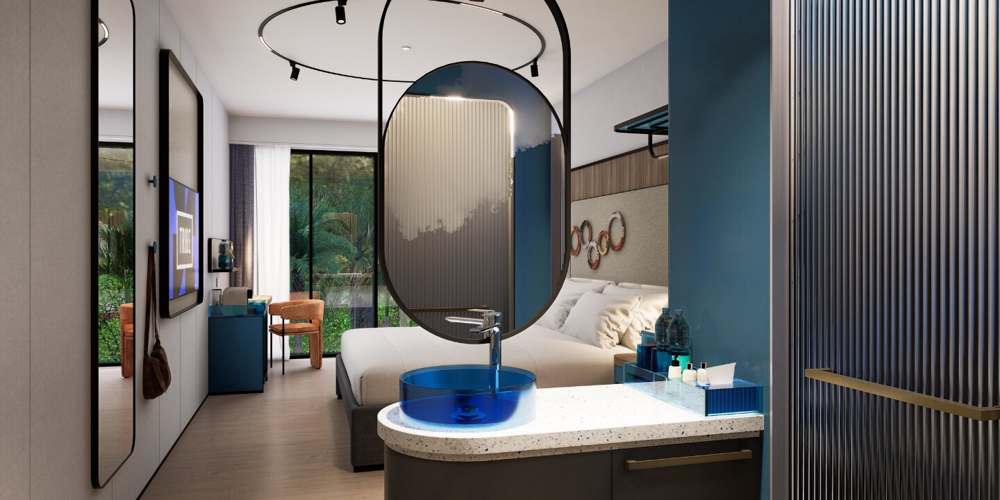 Boutique hotel king bedroom showcasing an open-concept washbasin vanity with a blue glass vessel sink and round suspended mirror.