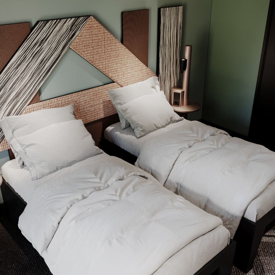 Two twin beds side-by-side in a contemporary hotel room, sharing a large, custom-designed geometric headboard with patterned fabric and striped panels.