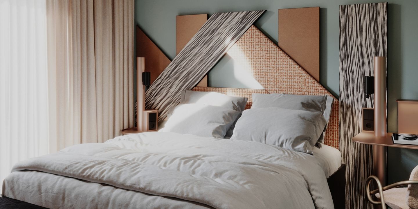 A double bed with white bedding, curtains and a geometric headboard.