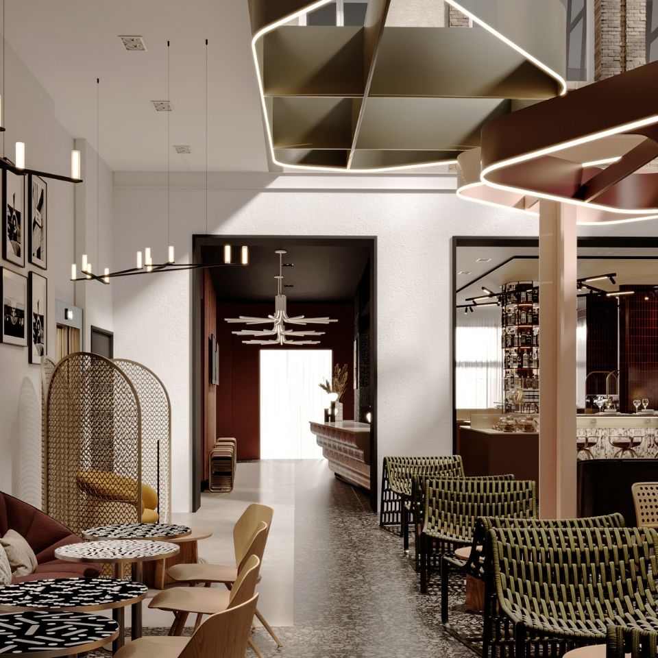 Lounge seating beneath a high ceiling and suspended sculptural forms.