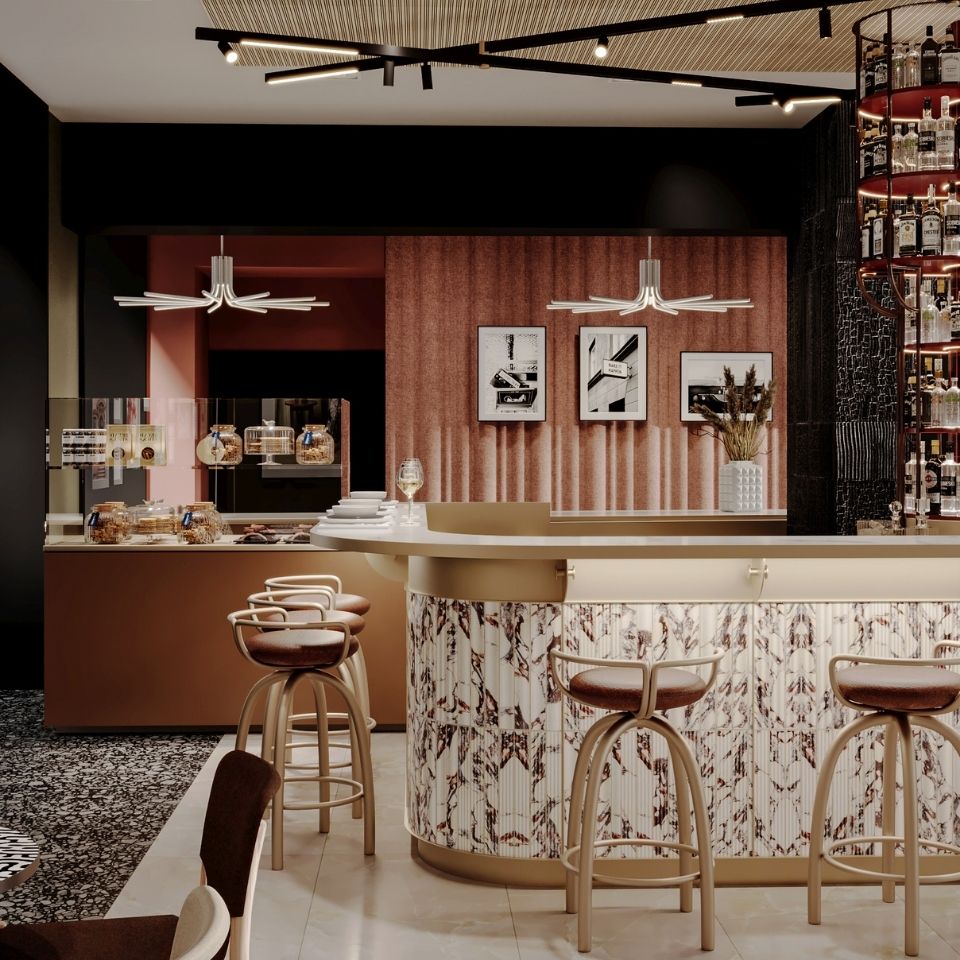 Bar stools at a marble counter beneath framed pictures.