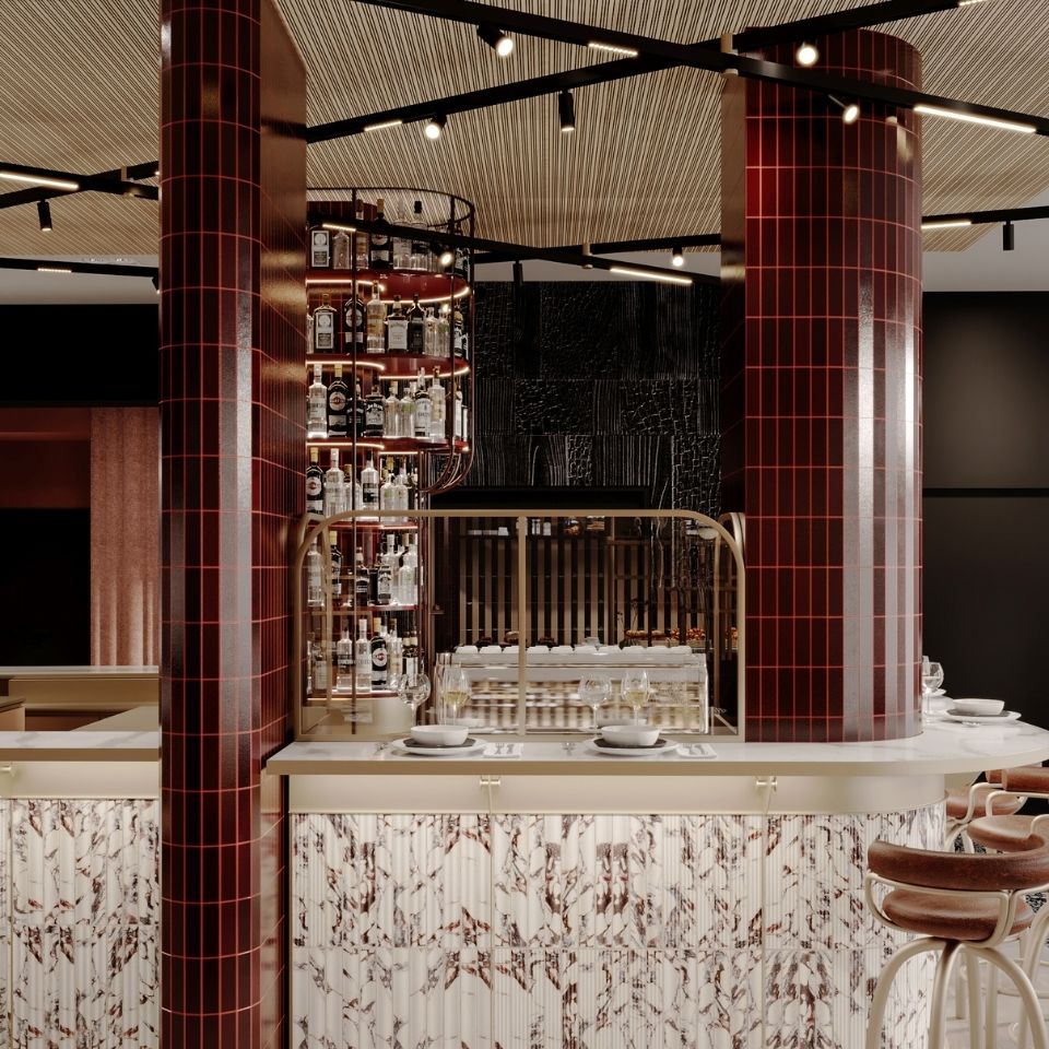 A marble-fronted bar beneath shelves framed by red tiled columns.