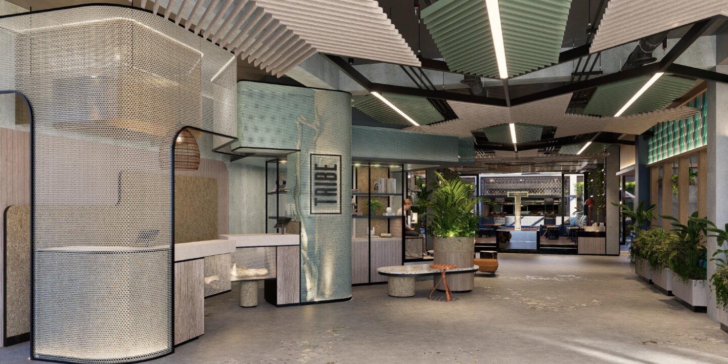 Modern lobby interior with curved textured walls, large planters, geometric ceiling panels, and a "TRIBE" sign on a central column.