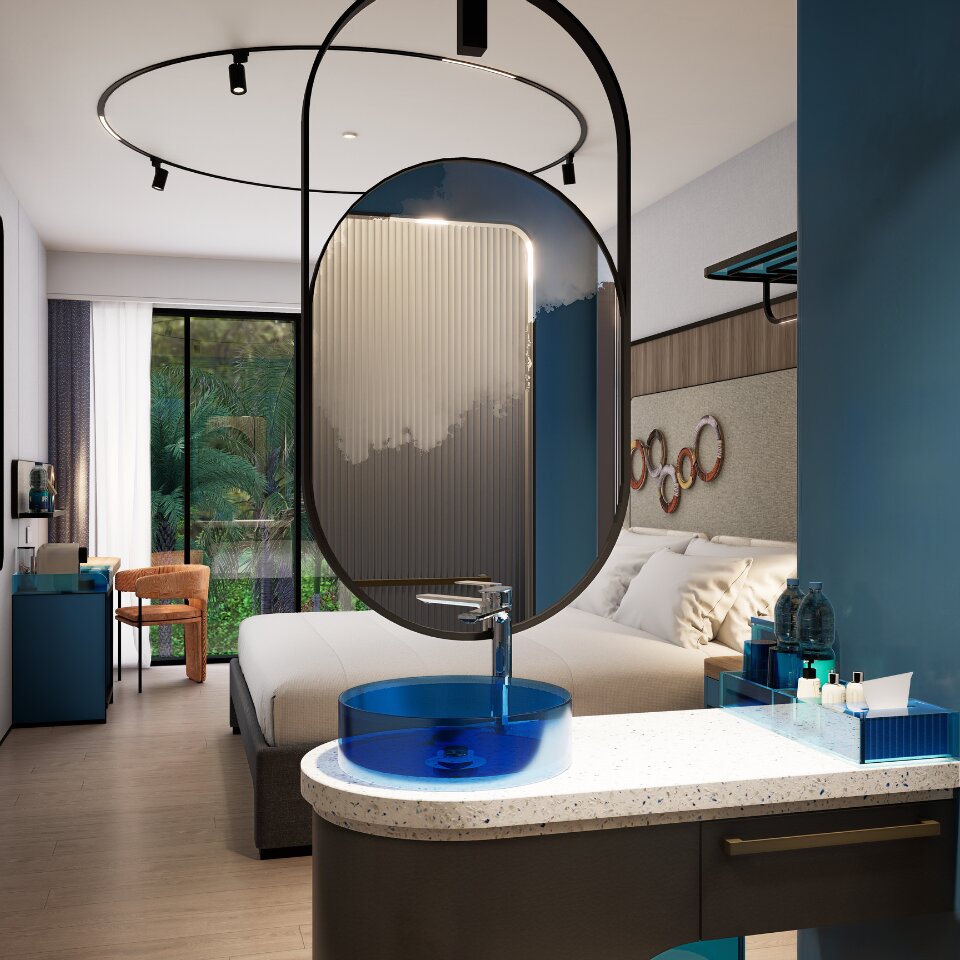 Modern boutique hotel bedroom featuring an integrated vanity with a translucent blue glass vessel sink and a suspended circular mirror.
