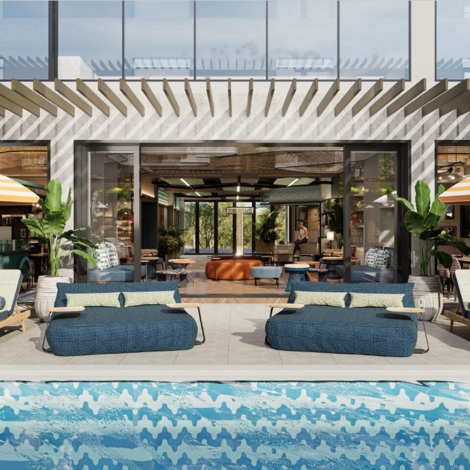 Modern resort swimming pool looking towards an open-air poolside bar and restaurant with hanging green plants.