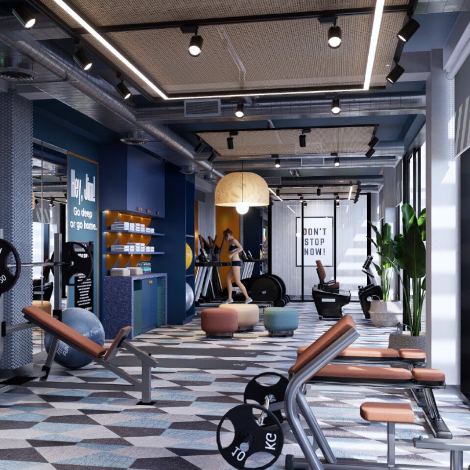 Fully equipped hotel fitness center featuring modern treadmills, weight benches, gym equipment, and motivational wall art.